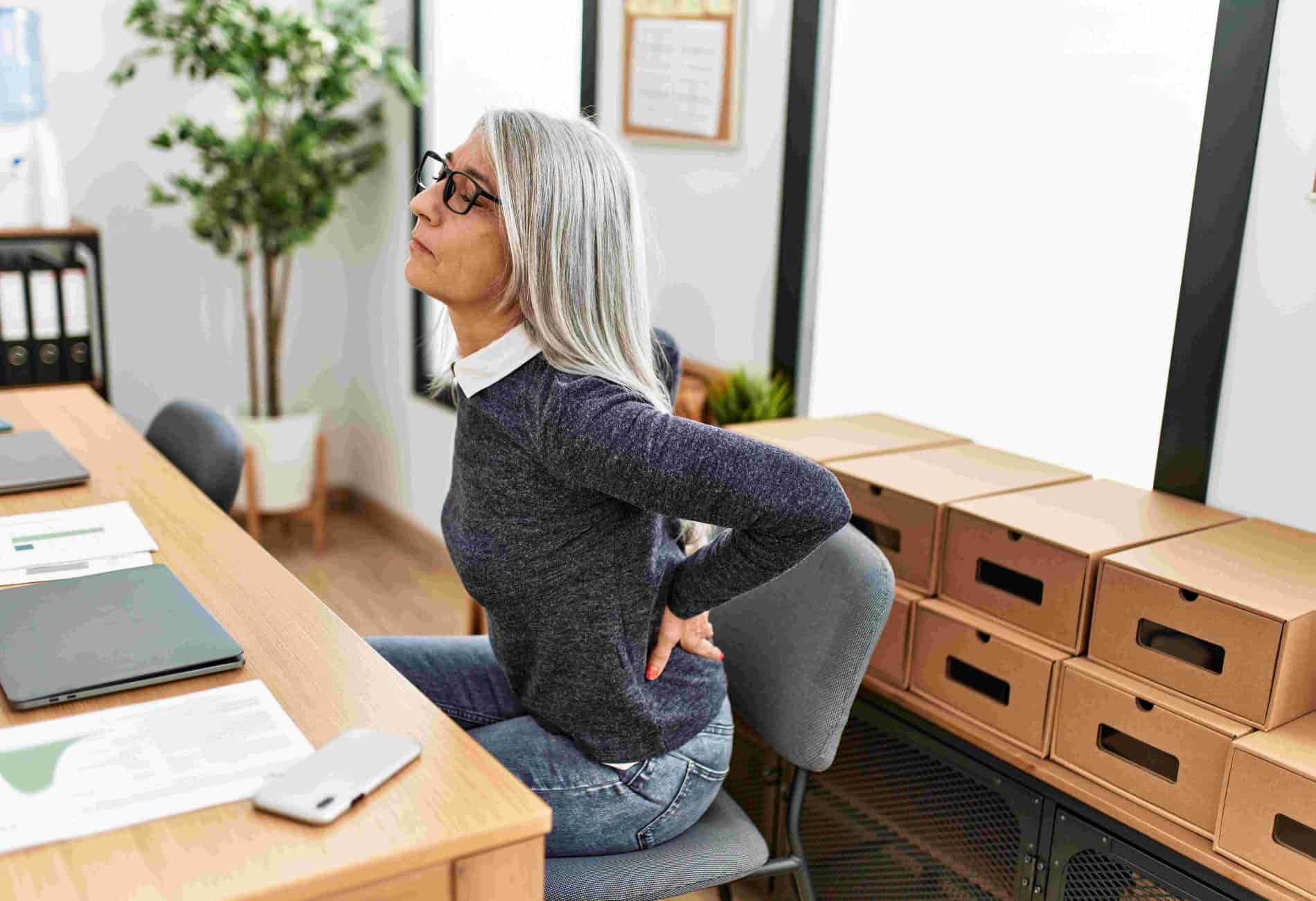 mulher sentada com dor nas costas ao respirar