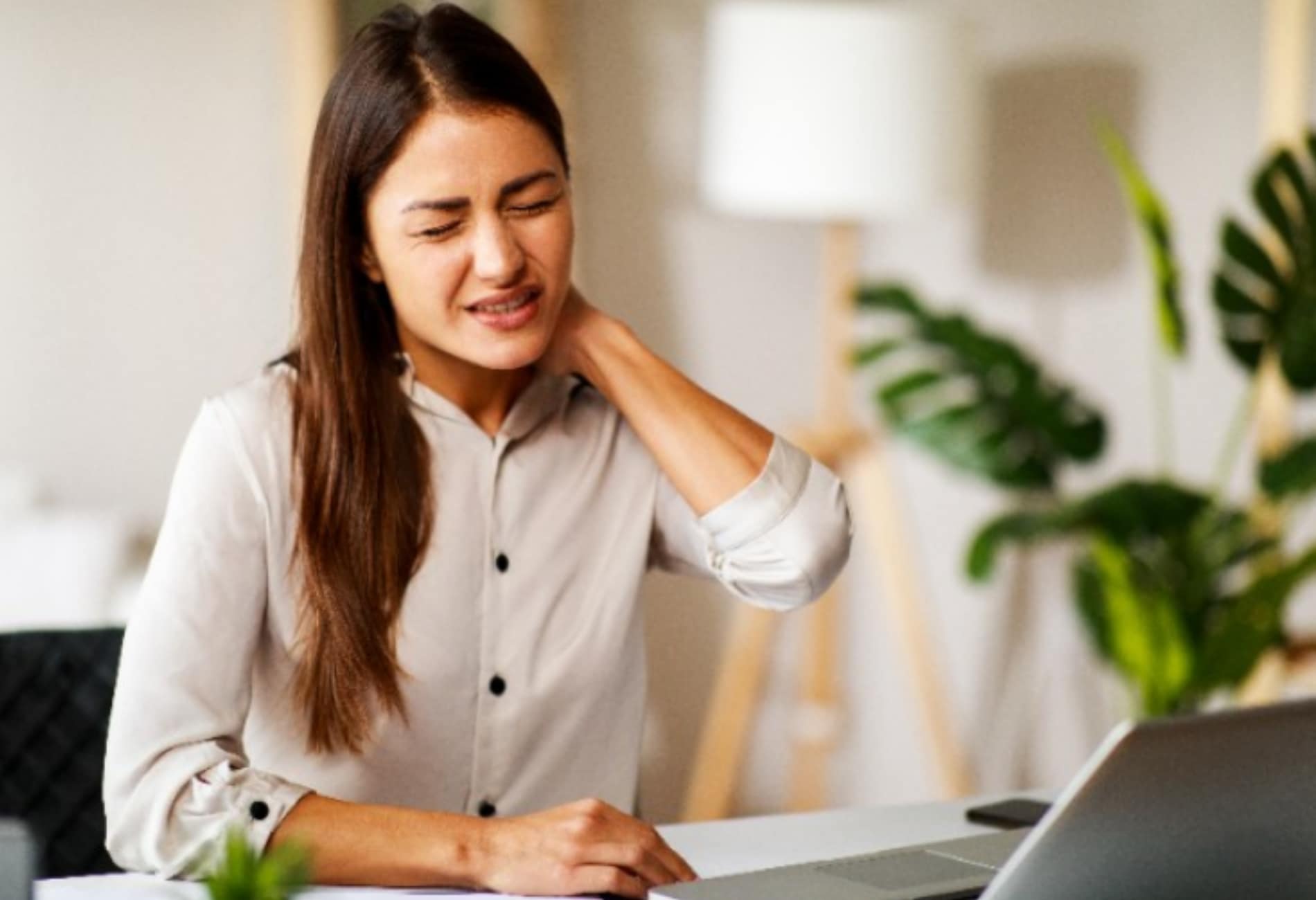 mulher com dor no pescoço no ambiente de trabalho