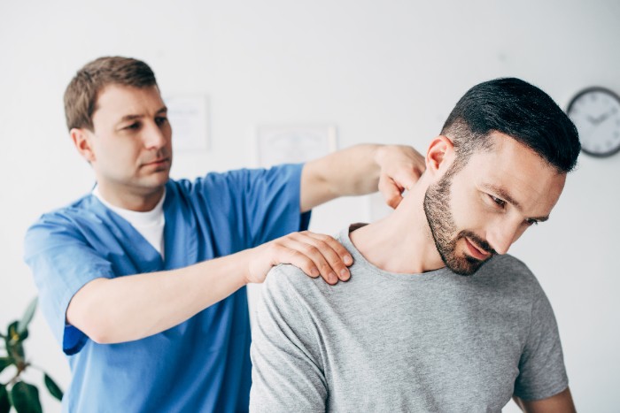 homem sinal de Lhermitte sendo examinado por um fisioterapeuta