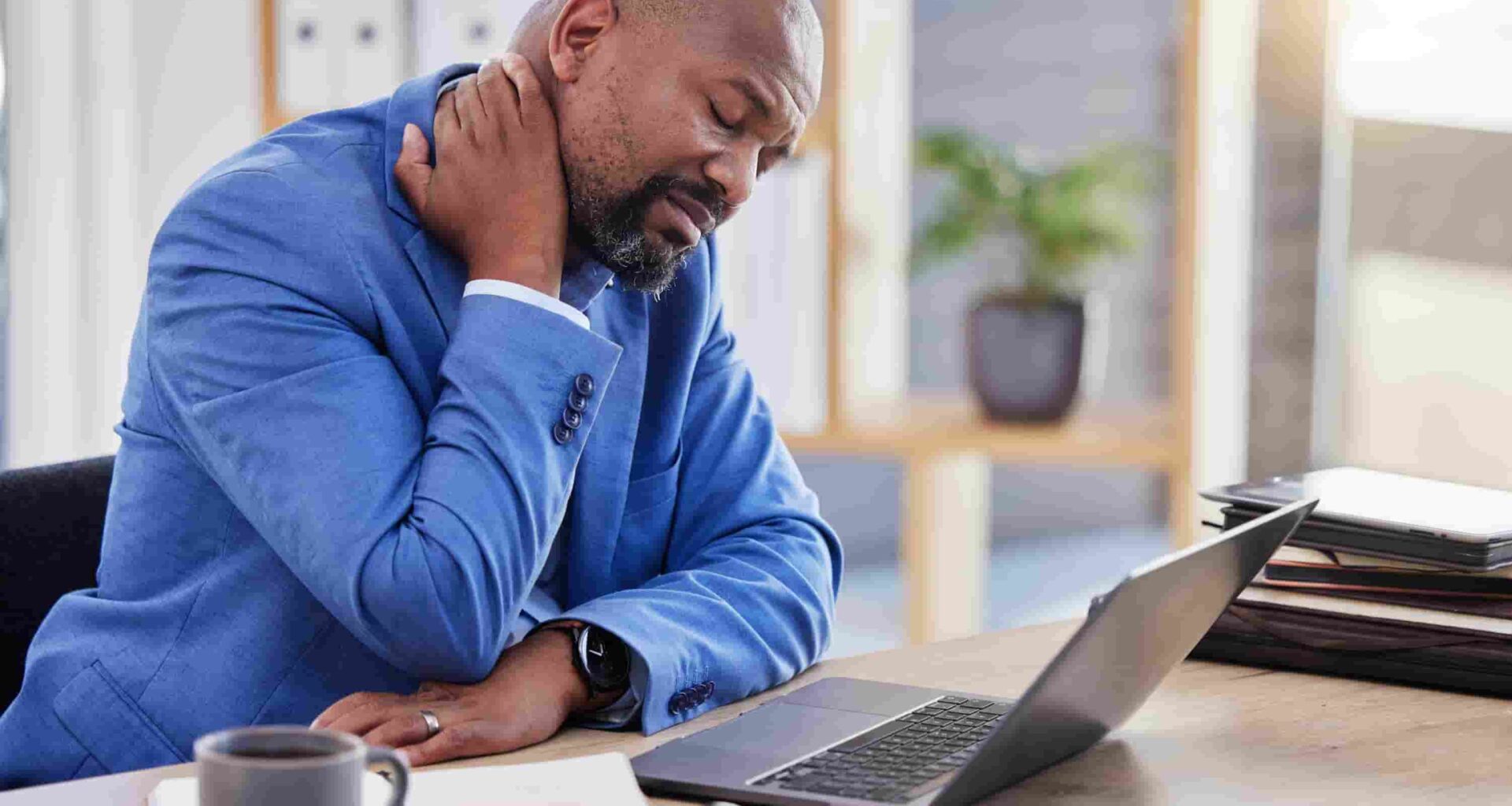 homem com dor na cervical no trabalho