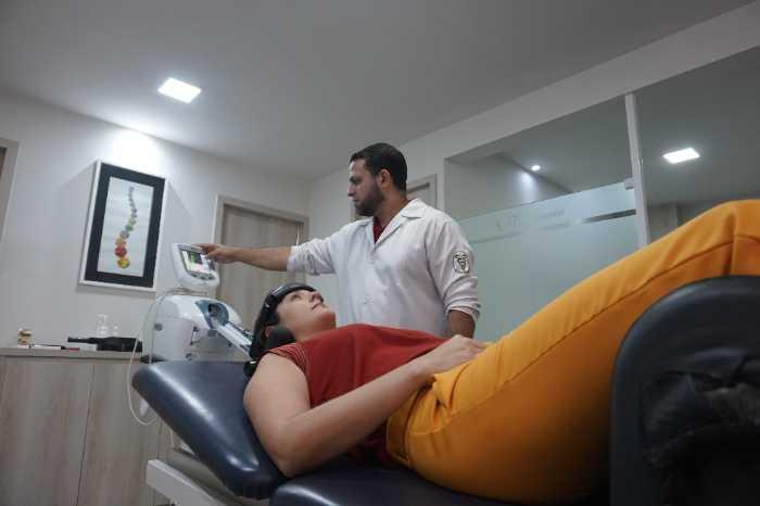 Paciente em sessão de fisioterapia para nervo ciático utilizando mesa de tração computadorizada