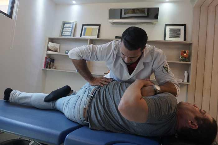 Fisioterapeuta realizando tratamento para coluna sem cirurgia em paciente com dor ciática