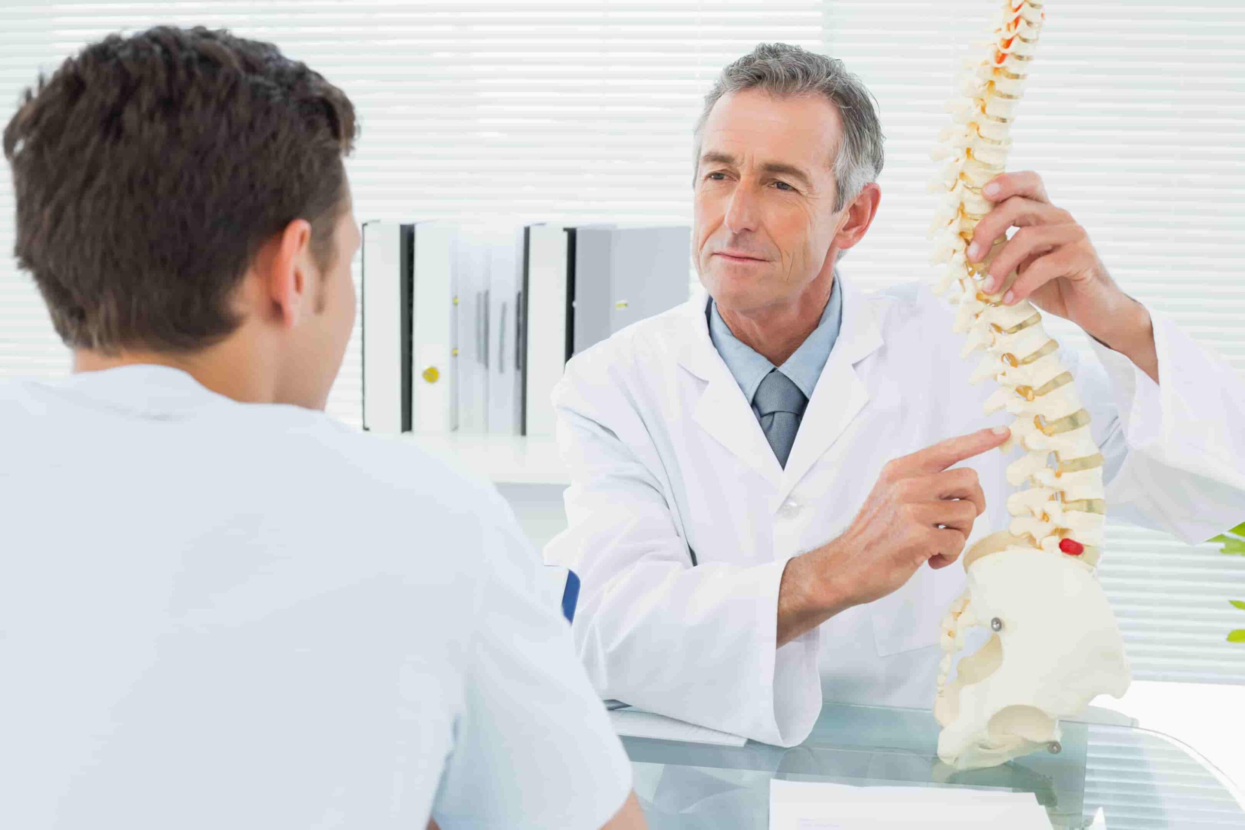 Fisioterapeuta explicando os riscos discectomia lombar ao paciente