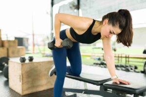 mulher fazendo remata unilateral com peso