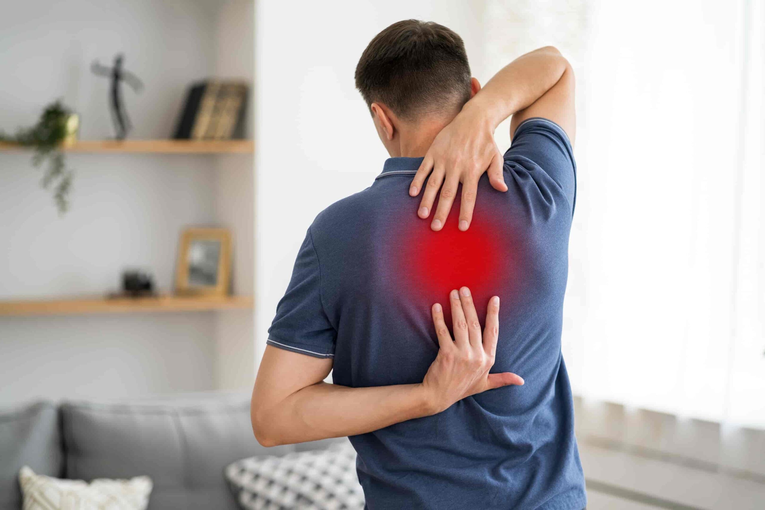 Homem de costas com as mãos na coluna torácica, onde um círculo vermelho ilustra o ponto exato da dor na parte de cima das costas.